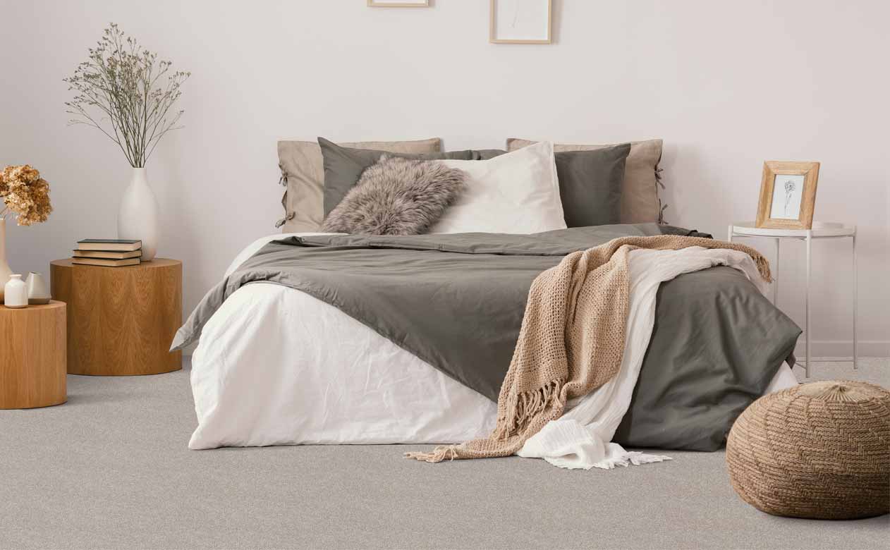 boho chic bedroom with bed, gray carpeted floor and wood accents